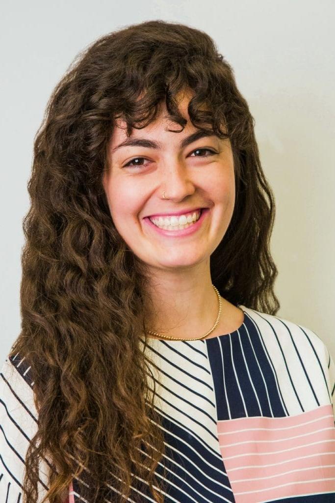 Smiling woman with curly hair and striped shirt.